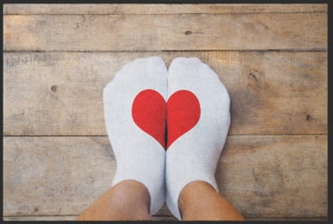 a person's feet in white socks with a red heart