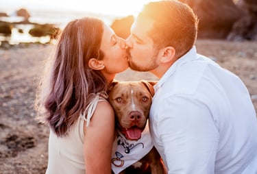 a man and woman kissing on the beach