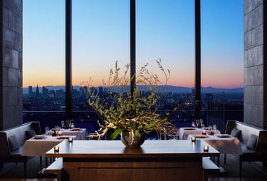 Aman Tokyo Elegant restaurant Avra with city view at sunset.