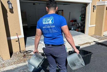 Top Tier Cooling technician carrying blower wheel components for professional HVAC maintenance services.