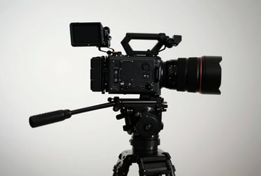 A high-end cinematic camera on a tripod silhouetted against a soft mist white studio background.