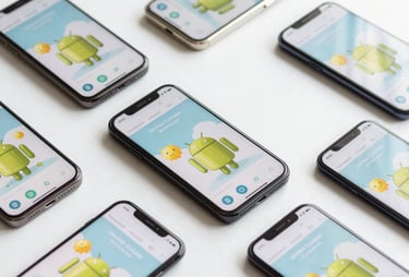 Clean, brightly lit flat-lay of several Android smartphones with different screen sizes, all showing the same playful app interface. International / European aesthetic.