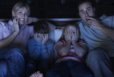 a family sitting on a couch watching tv
