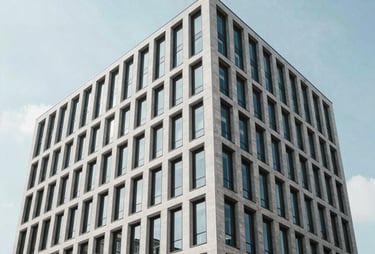 Clean, architectural shot of a modern office building in a European city like Berlin or Paris. Minimalist lines and bright sky.