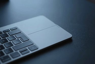 Minimalist detail of a keyboard and touchpad on a dark desk, soft blue lighting, professional feel.