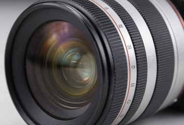 A close-up of a high-end studio camera lens, with soft blue and silver reflections. High resolution, professional photography equipment.