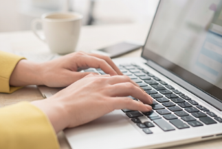 Hands typing on laptop