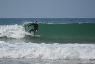 a man in a wetsuit surfing on a wave