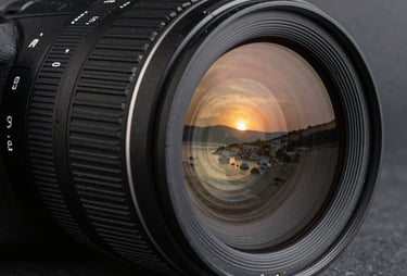 A professional camera lens reflecting the sunset of Bodrum, sharp focus, metallic textures, dark slate grey background.