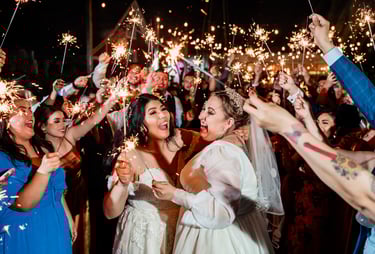 a bride and groomsmid are holding sparklers