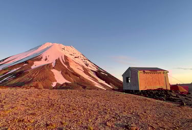 La luz del amanecer reflejada en el Taranaki junto a Syme Hut