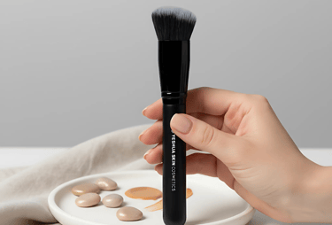 a person holding a foundation brush