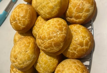 菠蘿包製成品「數個圓形金黃色 菠蘿包排放於烘焙紙盤上，表面紋理清晰、烘焙均勻，展現課堂麵包製作成果與質感細節。