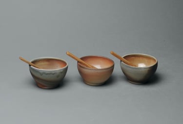 Set of three condiment bowls with wood spoons