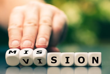 a person holding dices which together are spelling the word mission and vision