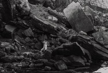 a person standing on a rocky cliff face in Portovenere