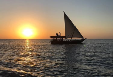Tourists enjoying a magical sunset on a traditional dhow cruise in Zanzibar, Tanzania.