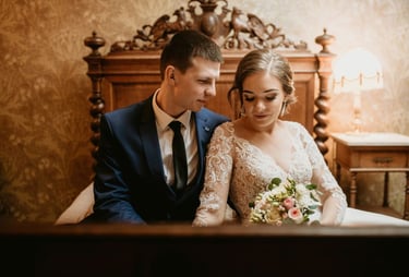 a bride and groom sitting on a bed