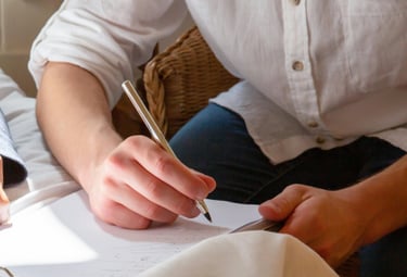 a person sitting on a bed with a pen and a pen