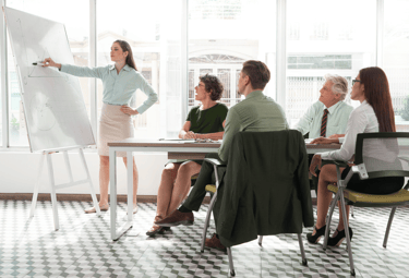 a woman in a business suit is standing in front of a white boardroom