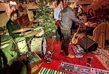 The full 4-piece Mosaic band performing live in a rustic barn venue with professional lighting