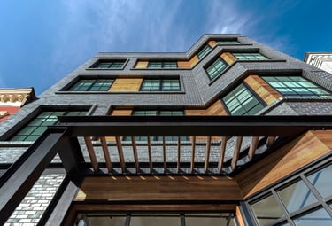 An architectural photograph of a grey brick apartment building