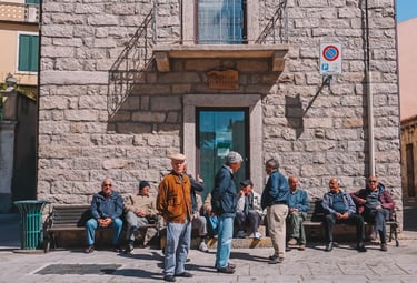 Elderly men chatting in the square of Luras village, Gallura Sardinia