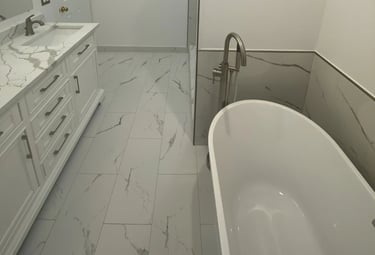 Contemporary bathroom with vanity and freestanding bathtub with marble tiles