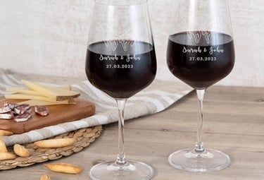 two wine glasses with wine glasses on a table