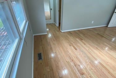 Hallway bedroom corner with bright hardwood floors and gray walls