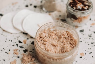 Scrub en natuurlijke verzorgingsproducten op een stenen schaal.