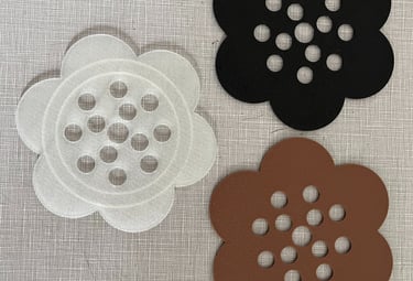 three plastic flower frogs in black, brown, and clear