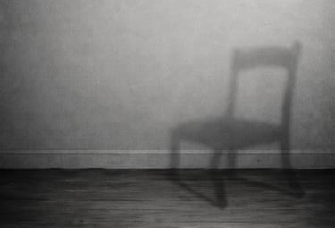 Minimalist black and white image of a chair casting a shadow