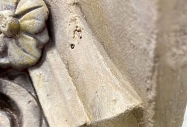 Close-up on capital of column with a painted sandstone faux finish.