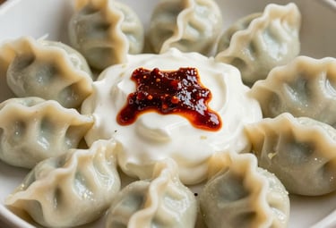 A traditional bowl of handmade Turkish Mantı dumplings topped with garlic yogurt and a drizzle of red pepper butter, warm lighting, natural styling