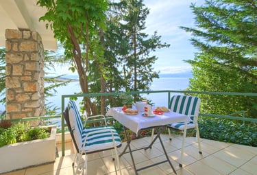 Cozy table and chairs on the apartment terrace with sea and Krk Island views