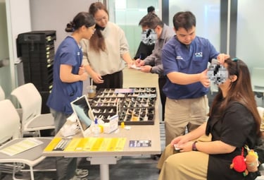 An optometrist doing an eye check for a lady participant in a health screening event
