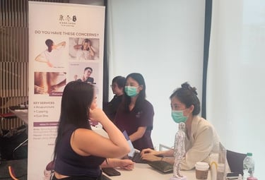 A female TCM physician doing a pulse check and consultation with a female patient