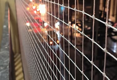 Close-up of a clean, well-maintained balcony safety net with sunlight filtering through.