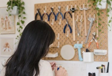 Fabricante de joyas en un banco de trabajo artesanal con herramientas en un tablero de herramientas