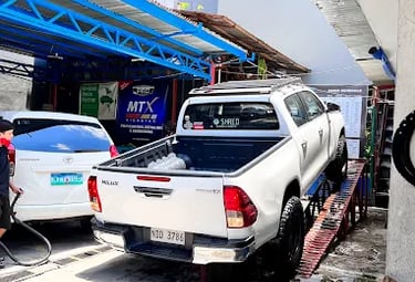 a truck parked in a parking lot with a man standing next to it
