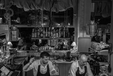 two barmen making at a bar 