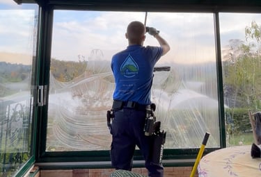 Un homme est entrain de nettoyer une véranda.