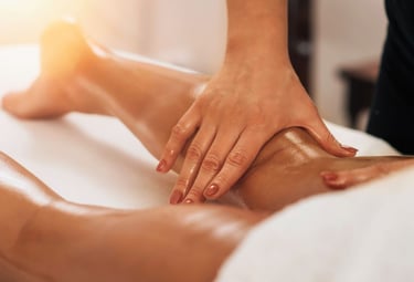 Une esthéticienne est en train de pratiquer un drainage lymphatique sur les jambes