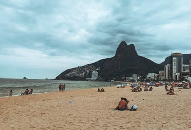 a beach with people sitting on the sand, Ipanema, Rio de Janeiro, Brazil
