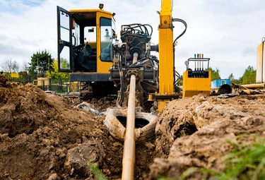 a construction worker is working on a pipe in the ground