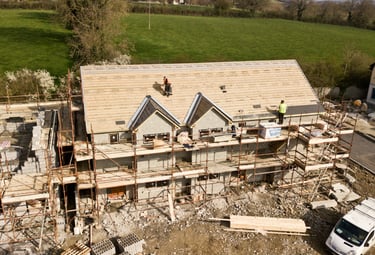 a house being built with a roof and a truck
