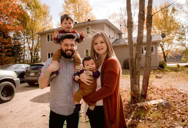 Happy family outside their new home in autumn, representing mortgage options for repeat home buyers