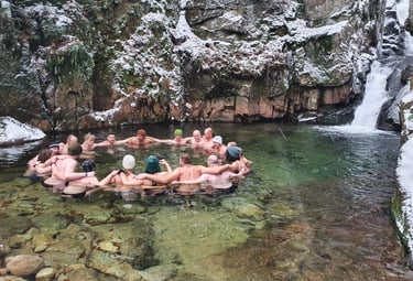 Eine Gruppe von Menschen beim Eisbaden am Wasserfall nach der Wim Hof Methode