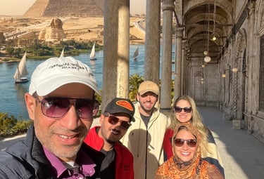 Guia profissional egiptólogo tira selfie com grupo de turistas brasileiros na colunata histórica da Cidadela do Cairo
